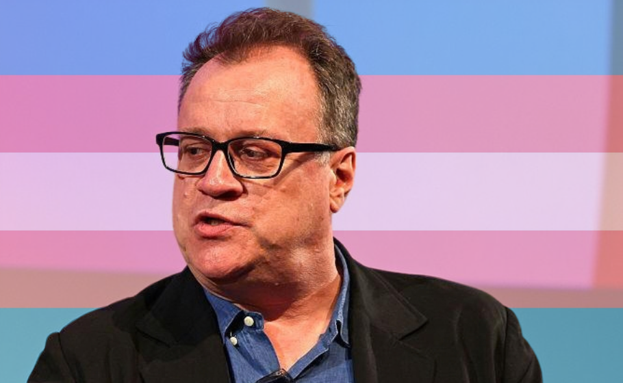 Russell T Davies speaking at a panel event with a trans flag added to the background