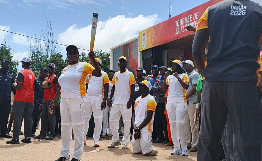 A torchbearer holds the Olympic flame during the Dakar 2026 Youth Olympic Games torch relay in Senegal.